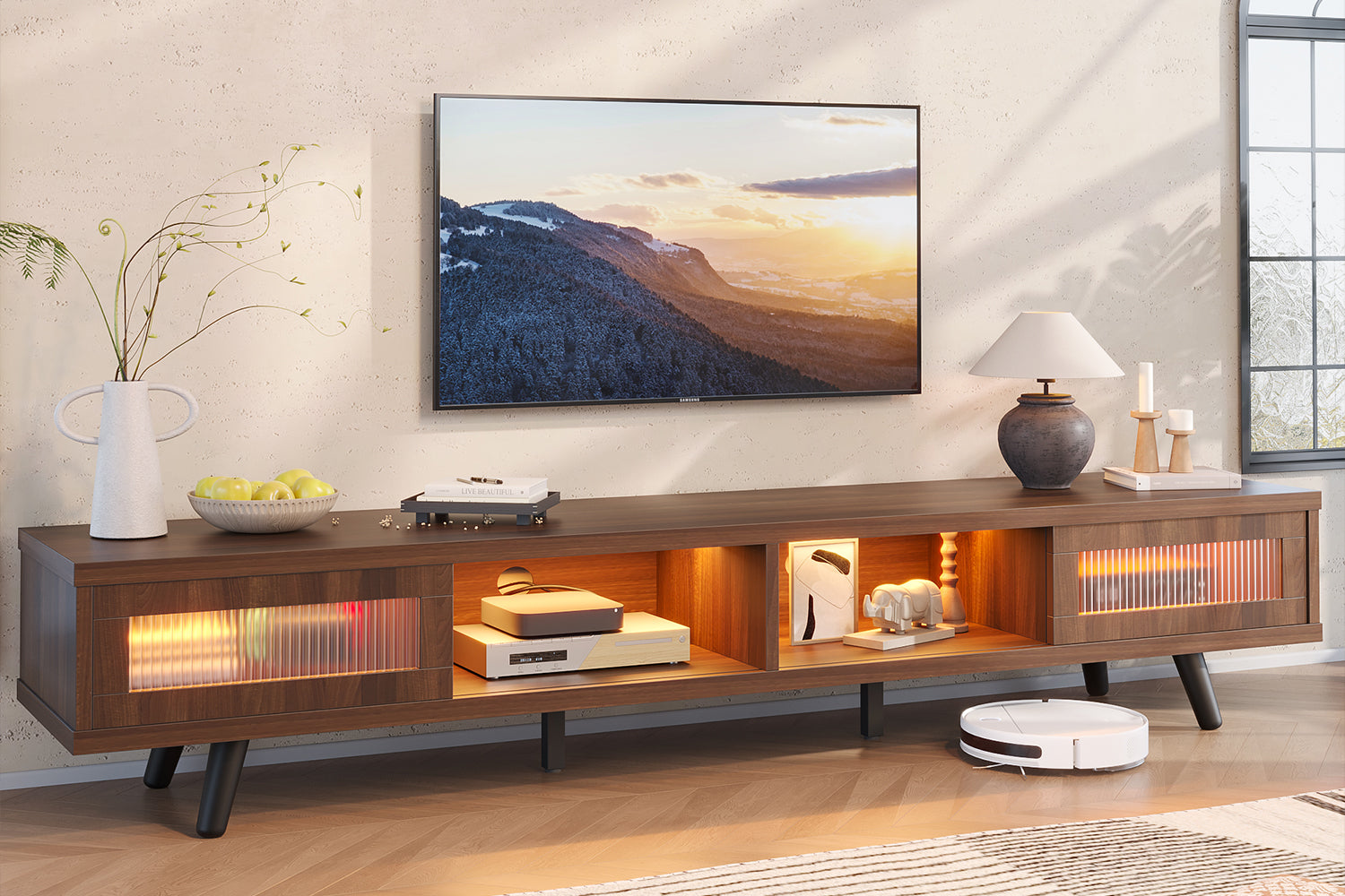A long, low-profile dark wood TV stand with warm LED lighting under a wall-mounted television in a modern living room.