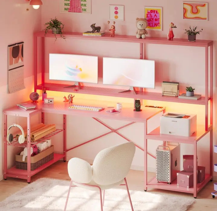 there are two computers on the pink l-shaped computer desk